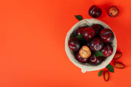 Decorative bowl with plums on an orange background.の写真素材