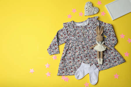 Concept of female baby clothes on yellow background.の写真素材