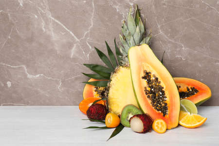 Ripe exotic fruits against gray textured background.