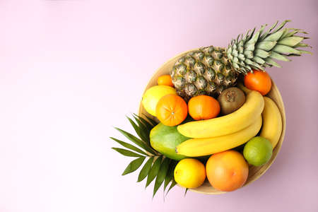 Bowl with exotic fruits on pink background.の写真素材