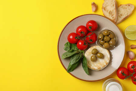 Concept of tasty food with grilled camembert on yellow background.の写真素材