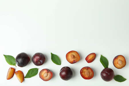 Tasty plums with leaves on white background.の写真素材