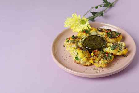 Concept of tasty food with baked cauliflower on violet background.の写真素材