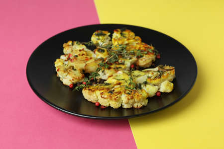 Plate with baked cauliflower on two tone background.