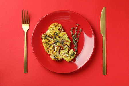 Concept of tasty eating with baked cauliflower on red background.の写真素材