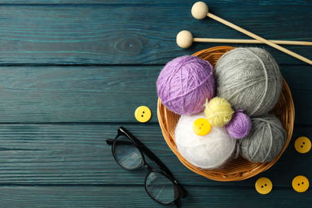 Knitting concept with yarn balls on wooden background.