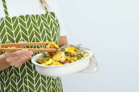 Woman holds baking tray with baked cauliflower.の写真素材