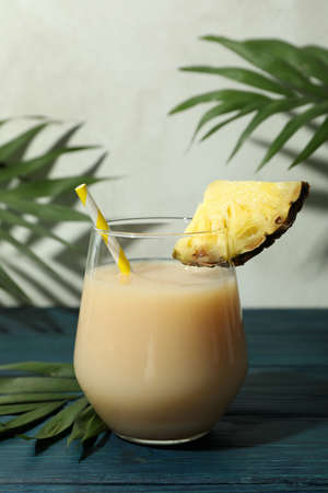 Pina colada cocktail on blue wooden table.