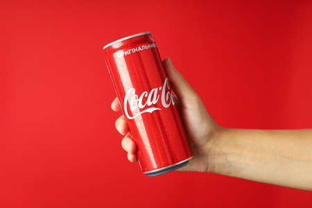 Odessa, Ukraine - September 23, 2021: Female hand holds Coca - Cola can on red backgroundのeditorial素材