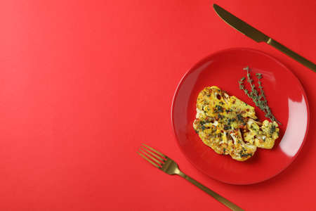 Concept of tasty eating with baked cauliflower on red background.の写真素材