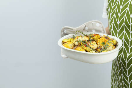 Woman holds baking tray with baked cauliflower.の写真素材