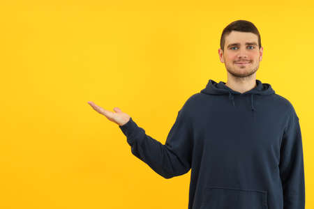 Young man on yellow background, space for text.の写真素材