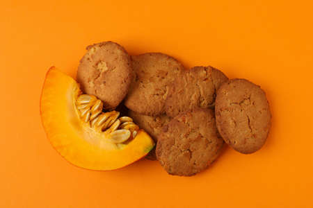 Pumpkin cookies on orange background, top view.