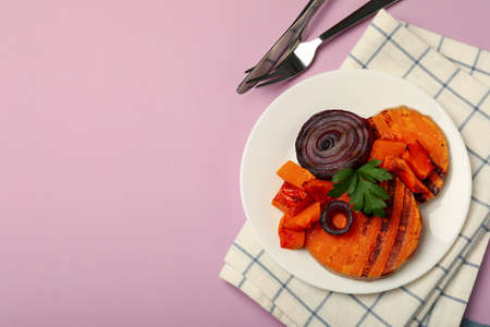 Concept of tasty food with baked pumpkin on violet background.の写真素材