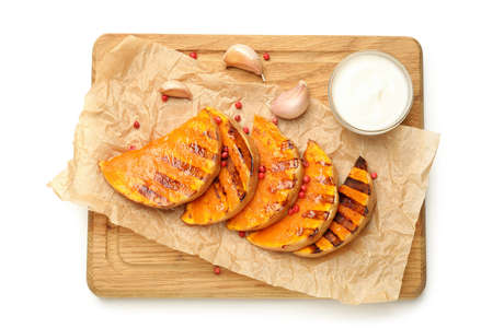 Board with baked pumpkin and spices isolated on white background.の写真素材