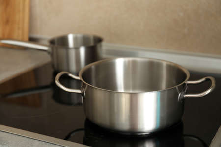 Metal pots on electric kitchen stove, selective focus.の写真素材