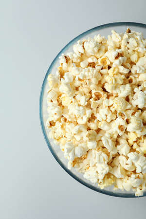 Glass bowl with popcorn on light gray background.の写真素材
