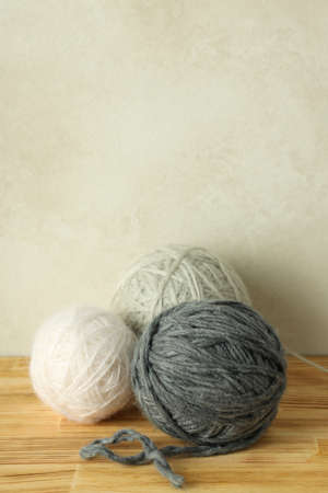 Multi colored balls of yarn on a light wooden table.の写真素材