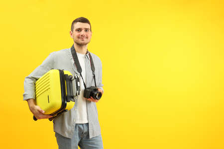Traveling concept with young man on yellow background, space for text.の写真素材