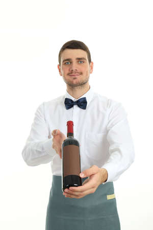 Young man waiter holds bottle of wine, isolated on white background.の写真素材