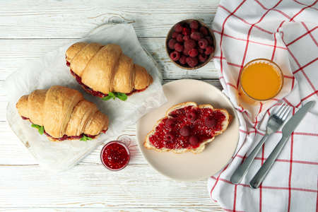 Concept of delicious food with croissants with raspberry jam on white wooden backgroundの写真素材