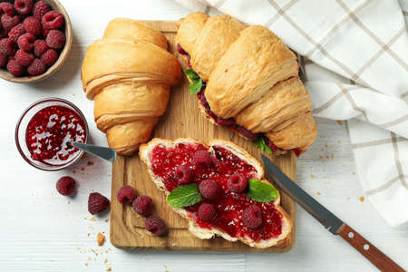 Concept of delicious food with croissants with raspberry jam on white wooden backgroundの写真素材