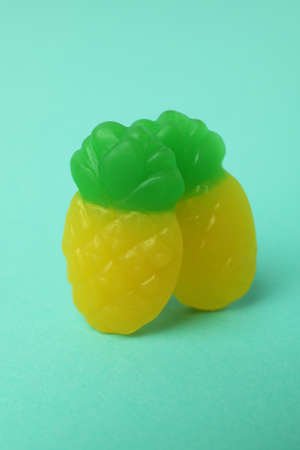 Gummy candies in the form of pineapple on mint background.の写真素材