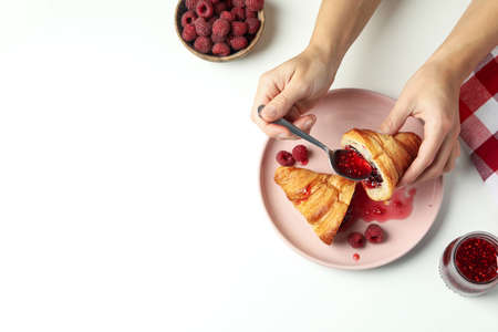 Concept of tasty eating with croissant with raspberry jam on white backgroundの写真素材