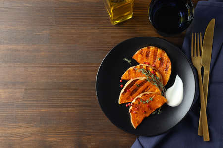 Concept of tasty eating with baked pumpkin on wooden background.の写真素材