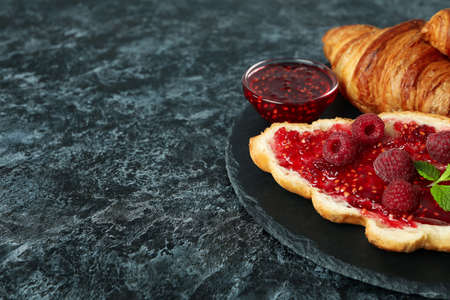 Concept of delicious food with croissants with raspberry jam on black smokey backgroundの写真素材