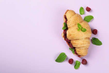Croissant with raspberry jam on purple backgroundの写真素材
