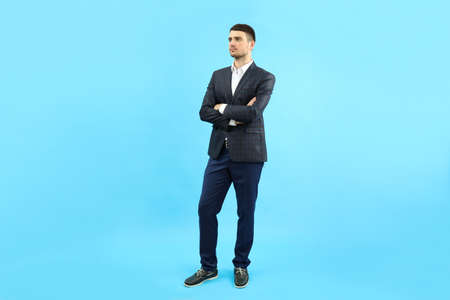 Young businessman in classic suit on blue background.の写真素材
