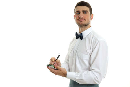 Young man waiter with notebook and pen, isolated on white background.の写真素材
