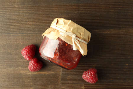 Jar of raspberry jam with ingredients on wooden backgroundの写真素材