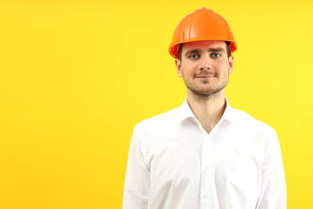 Businessman builder on yellow background, space for text.
