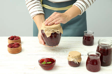 Concept of cooking raspberry jam on white wooden table.の写真素材