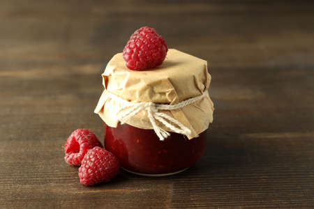 Jar of raspberry jam with ingredients on wooden backgroundの写真素材