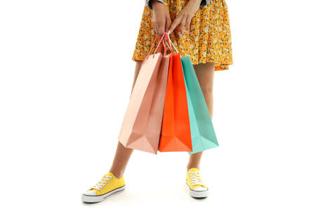 Girl with multicolored paper bags isolated on white background.の写真素材