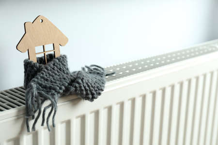 Concept of heating season with wooden house on heating radiator.の写真素材
