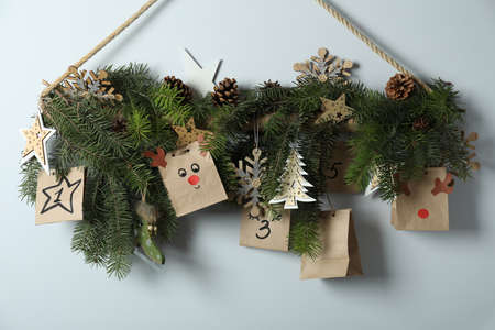 Christmas Advent calendar with spruce twigs hanging on wall.の写真素材