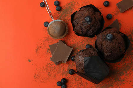 Concept of delicious food with chocolate muffins on orange background.の写真素材