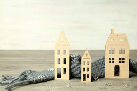 Concept of heating season with wooden houses on gray textured table.の写真素材