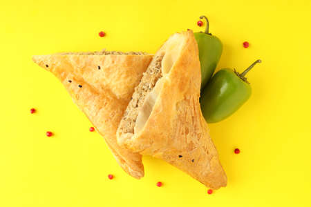 Golden samsa with ingredients on yellow background