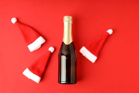 Champagne bottle and Santa hats on red background.の写真素材