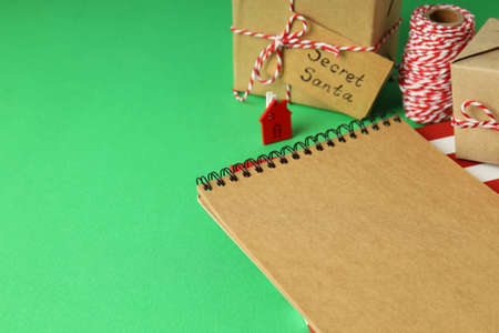 Secret Santa and Christmas composition on green background.