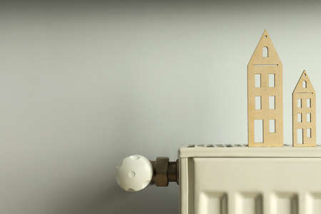 Concept of heating season with wooden houses on radiator.の写真素材
