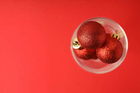 Champagne glass with baubles on red background.の写真素材