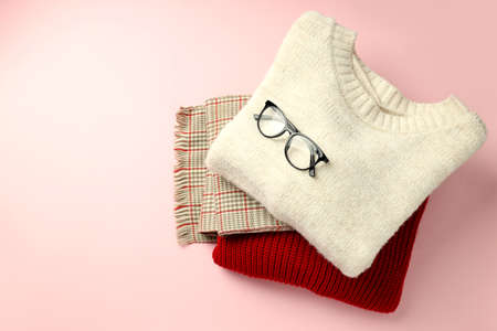 Sweaters and scarf with glasses on pink background.の写真素材