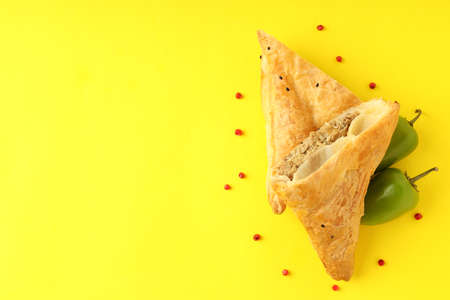 Golden samsa with ingredients on yellow background