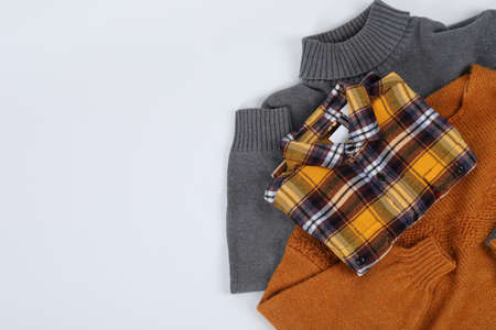 Sweaters with shirt on white background, space for text.